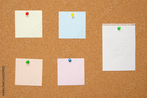 Bulletin board wich memo cards and white sheet of paper