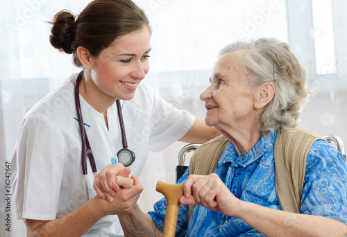 Murais de parede Senior woman is visited by her doctor or caregiver