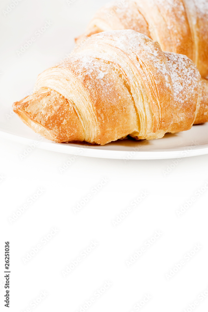 fresh croissants on white plate with empty space below