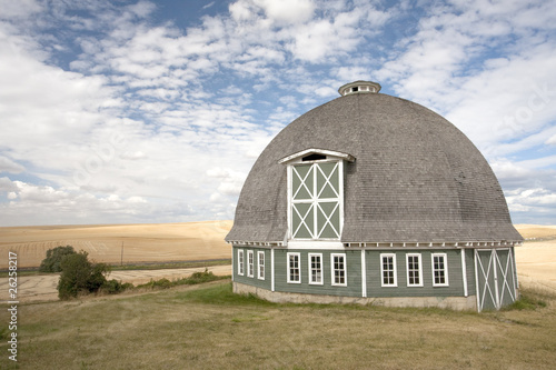 Принти на полотні A scenic view of a round barn with a blue sky in the background.