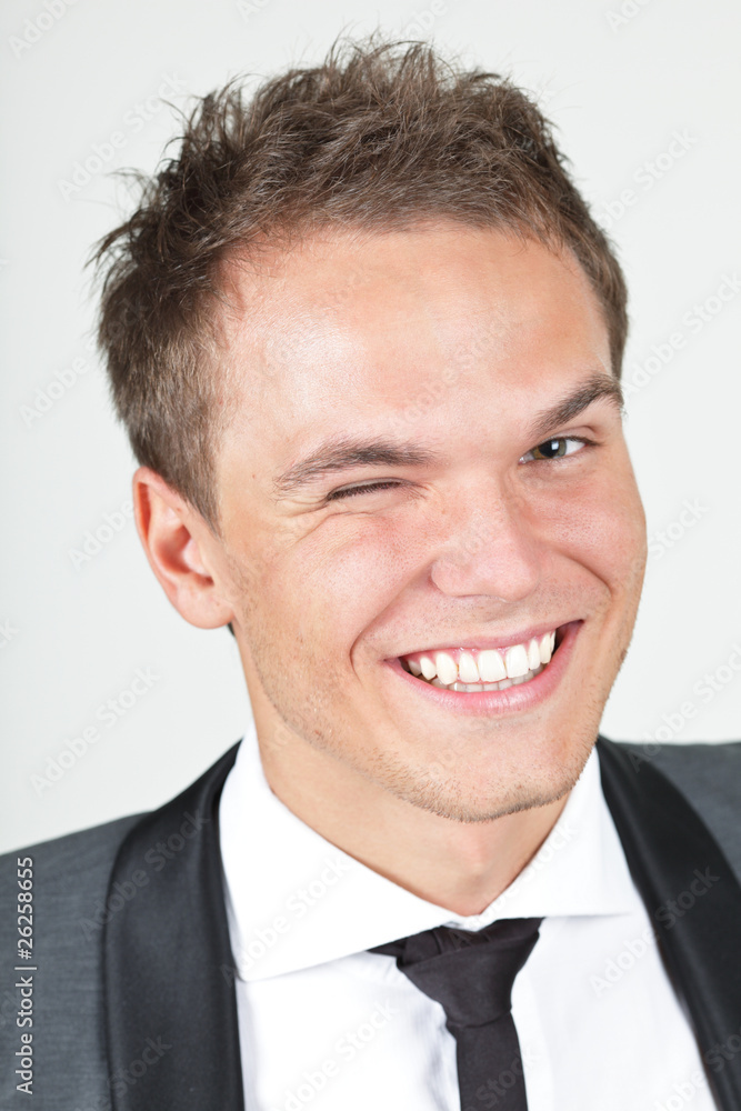 A young businessman, looking satisfied, giving a wink A young businessman, looking satisfied, giving a wink