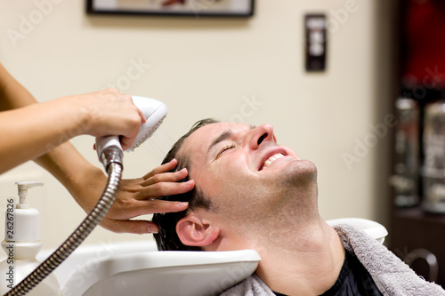 Handsome man having his hair washed