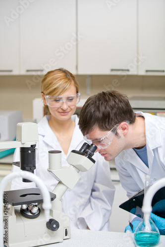 Caucasian scientists holding clipboard and looking through a mic