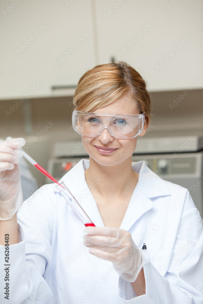 Close-up of a female scientist putting liquid in a test tube wit Close-up of a female scientist putting liquid in a test tube wit