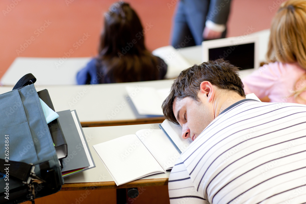 Asleep male student during an university lesson Asleep male student during an university lesson