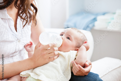 Bright mother feeding her adorable son in the kitchen