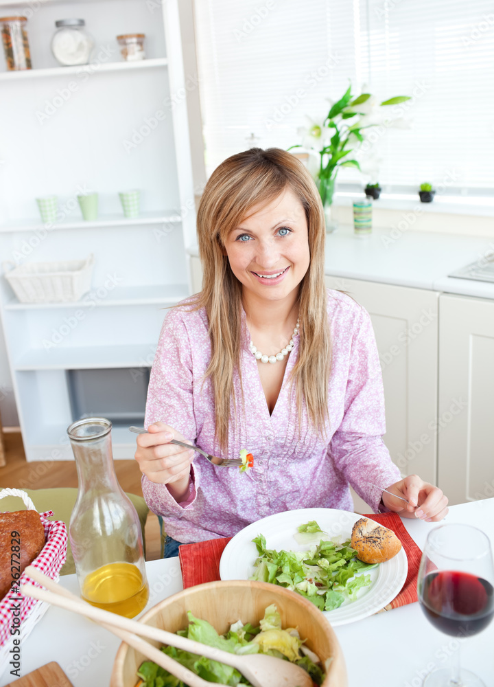 Beautiful woman eating salad in the kitchen Beautiful woman eating salad in the kitchen