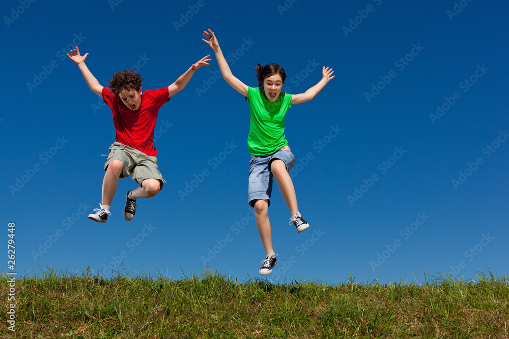 Girl and boy jumping, running against blue sky Girl and boy jumping, running against blue sky