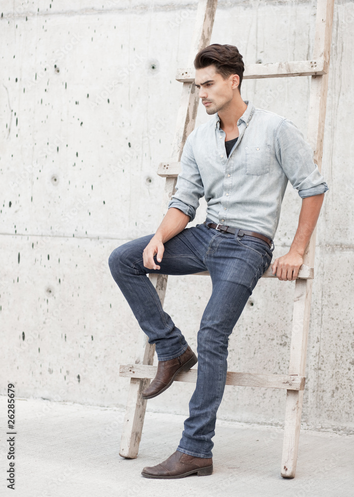 attractive man dressed in a blue jeans shirt, jeans and a cap attractive man dressed in a blue jeans shirt, jeans and a cap