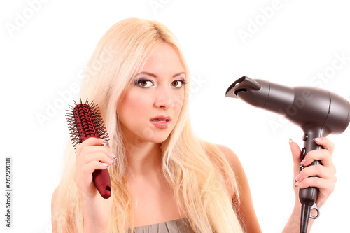 Beautiful young blonde woman brushing her long hair