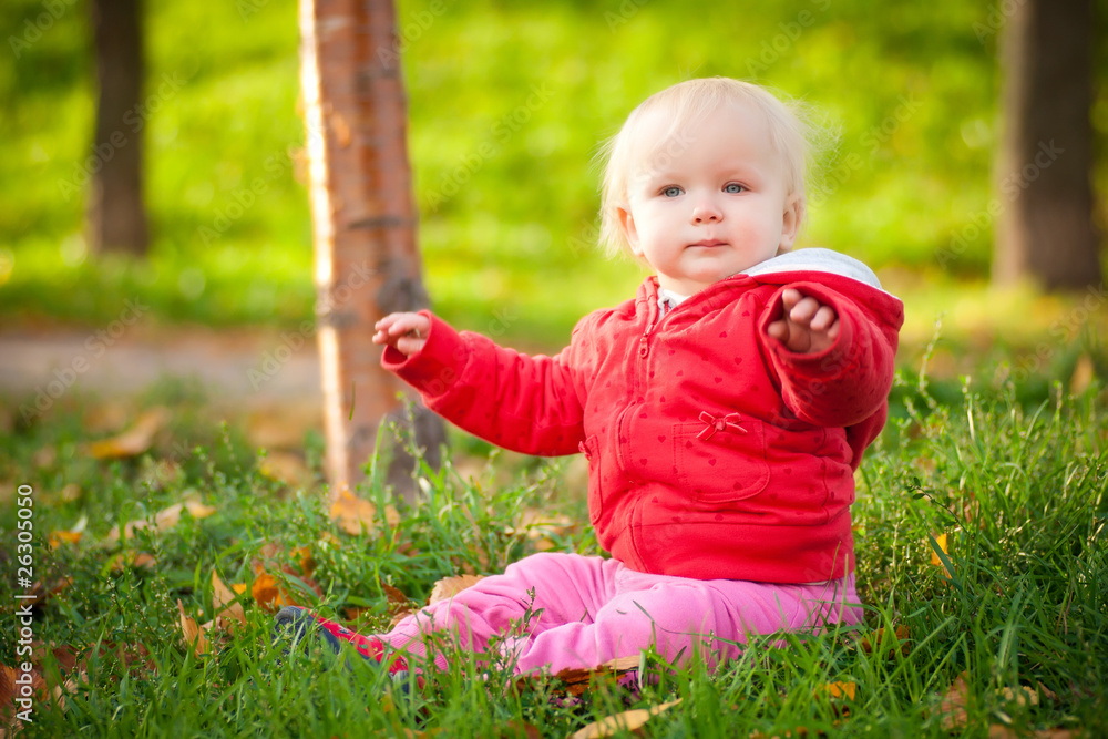 young adorable cheerful baby sit in park on green grass play wit young adorable cheerful baby sit in park on green grass play wit