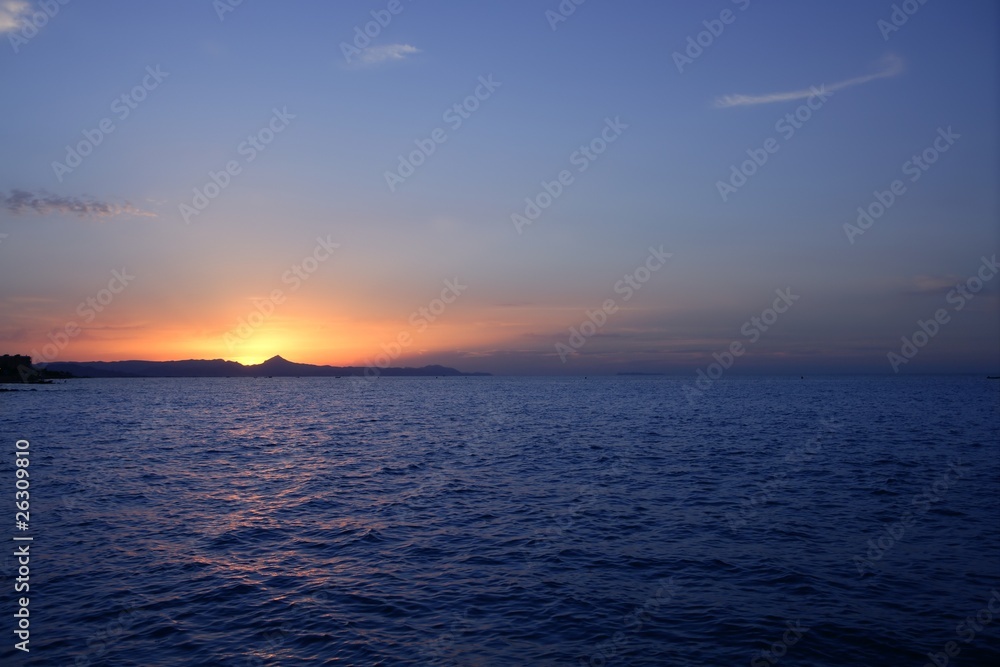 Beautiful sunset sunrise over blue sea ocean red sun sky