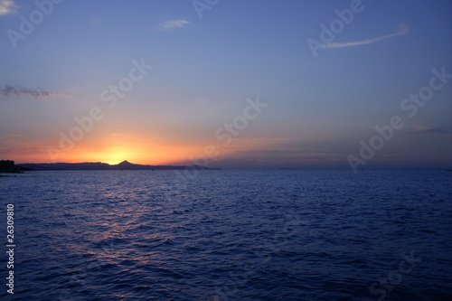 Beautiful sunset sunrise over blue sea ocean red sun sky