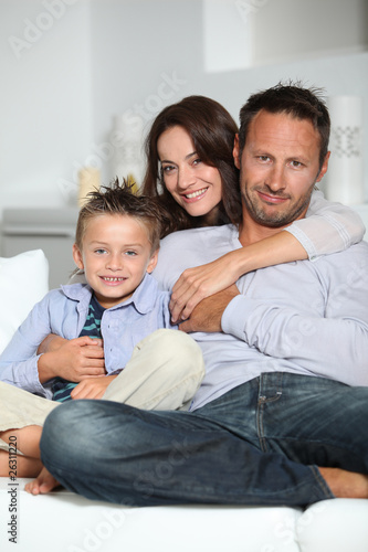 Closeup of parents and child relaxing at home on sofa