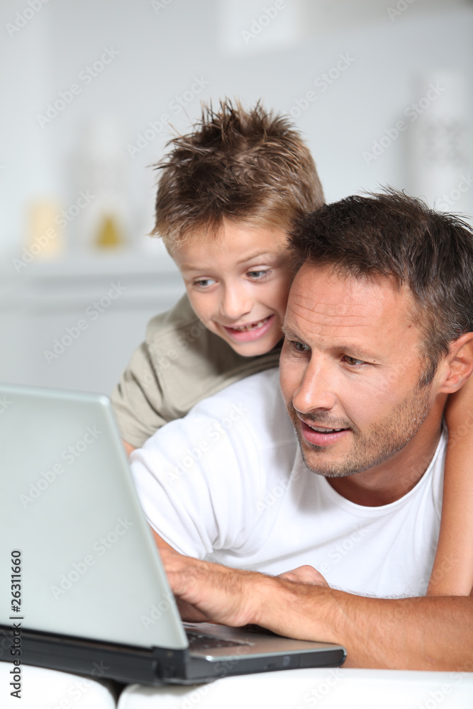 Father and son connected on internet at home Father and son connected on internet at home
