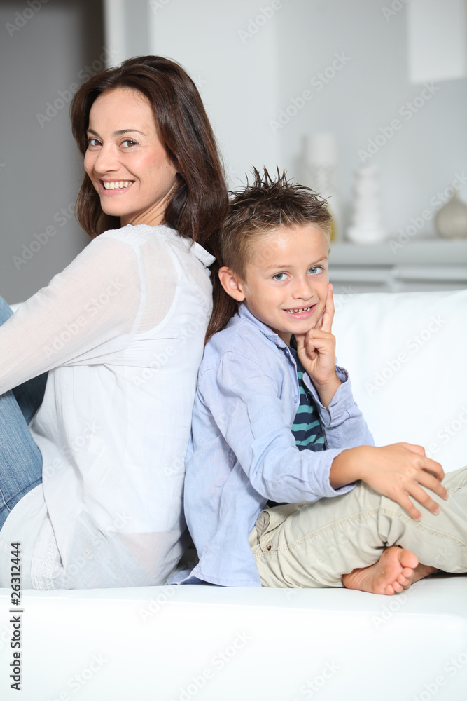 Little blond boy sitting on sofa with mom Little blond boy sitting on sofa with mom