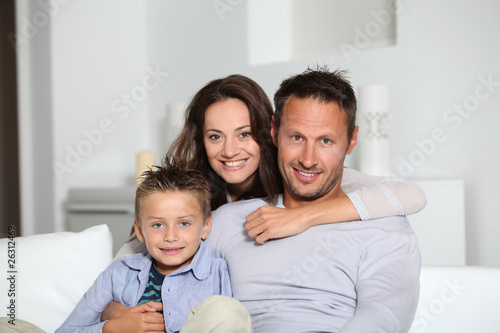Closeup of parents and child relaxing at home on sofa