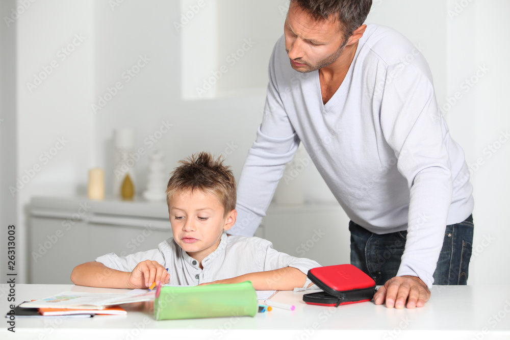 Father helping son to do homework Father helping son to do homework