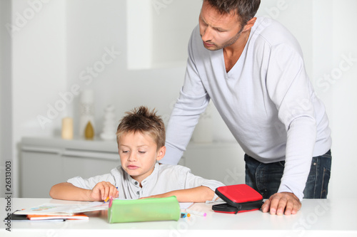 Father helping son to do homework © goodluz