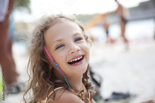 close-up portrait of a cute laughing girl at a beach