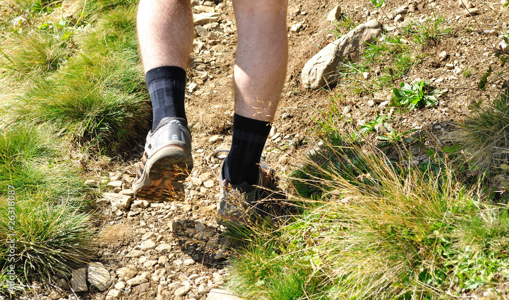Man runs along a mountain path, closeup feet, sneakers Man runs along a mountain path, closeup feet, sneakers