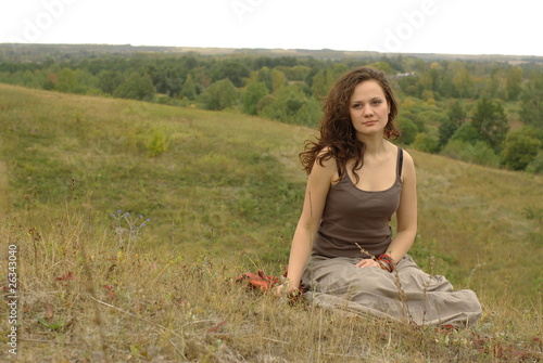 Female sitting in the autumn field