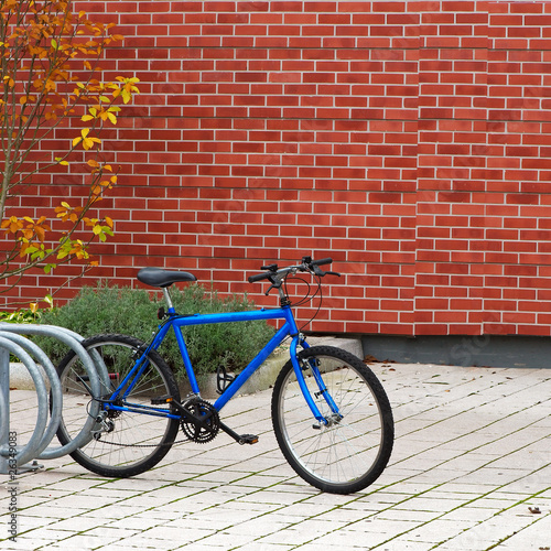 vélo bleu sur le parking attaché avec un antivol