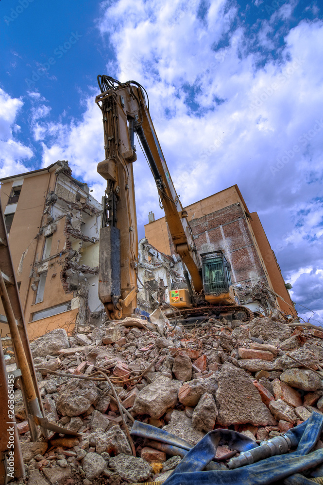 Fototapeta premium Escavatore con palazzi in demolizione