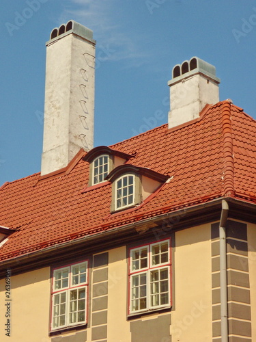 Red roof with tall white cimney and dormers