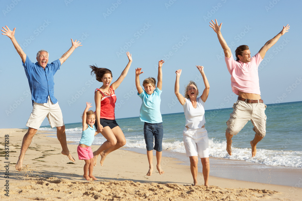 Portrait Of Three Generation Family On Beach Holiday Jumping In Portrait Of Three Generation Family On Beach Holiday Jumping In