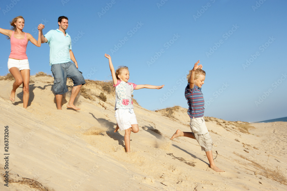 Family Enjoying Beach Holiday Running Down Dune Family Enjoying Beach Holiday Running Down Dune