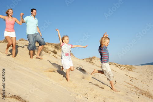 Family Enjoying Beach Holiday Running Down Dune