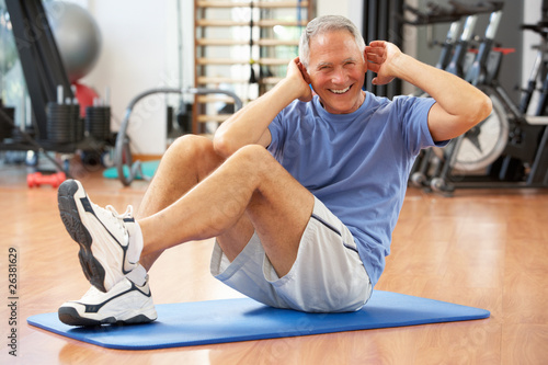фотографія Senior Man Doing Sit Ups In Gym