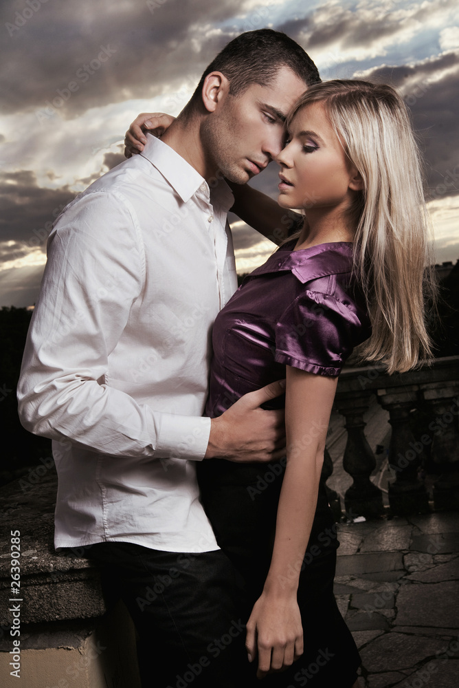Naklejka premium Beautiful couple hugging over cloudy sunset