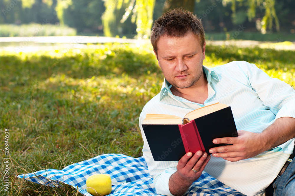 Fototapeta premium Young man reads book