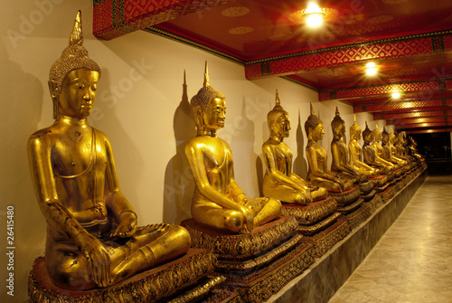 Buddha images in Thai temple at night in ambient golden lights