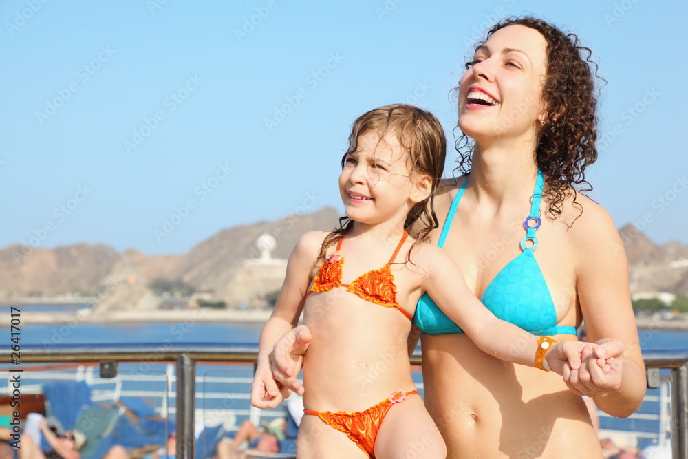 smiling woman with daughter is standing on deck of cruise ship smiling woman with daughter is standing on deck of cruise ship