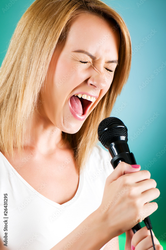 Girl singing with microphone against gradient background Girl singing with microphone against gradient background