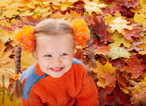 Girl child in autumn orange leaves.