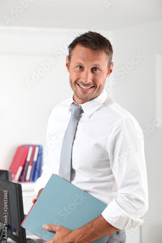 Happy businessman with thumb up in the office photo