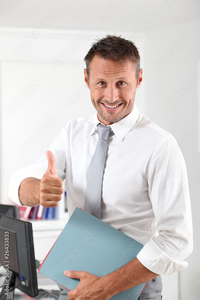 Happy businessman with thumb up in the office Happy businessman with thumb up in the office