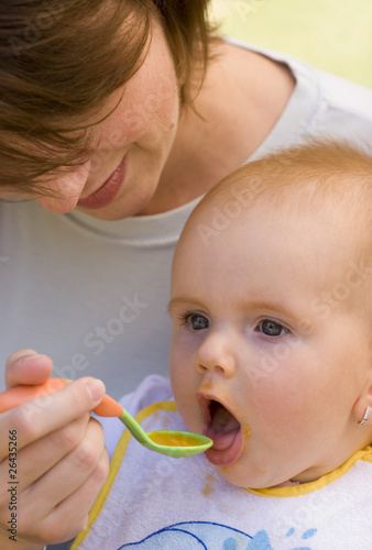 Mother feed her young baby