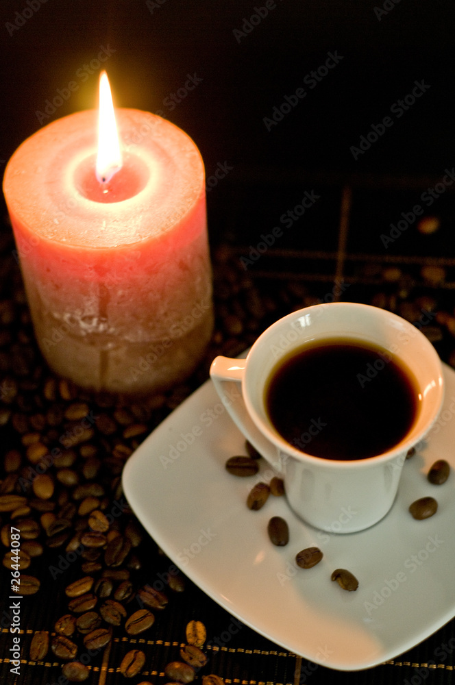 Cup of the fresh coffee and candle on the black background. Cup of the fresh coffee and candle on the black background.