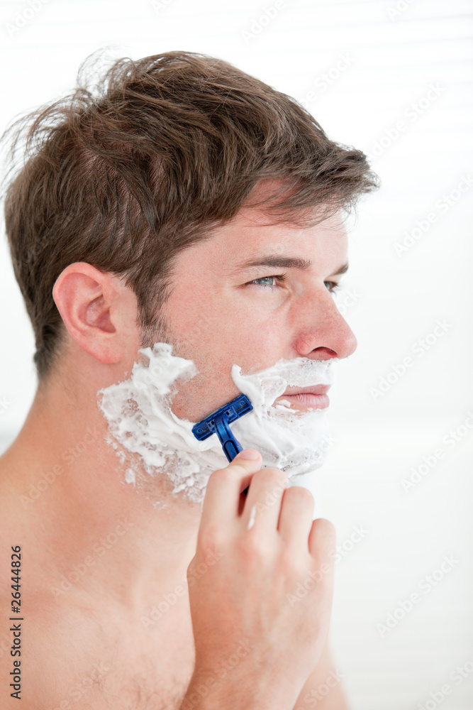 portrait of a serious man shaving looking away standing in the b portrait of a serious man shaving looking away standing in the b