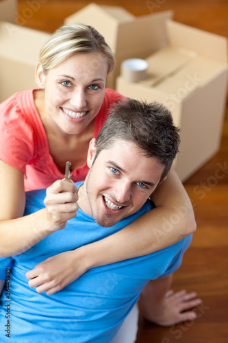 portrait of a joyful couple in their new house with woman showin