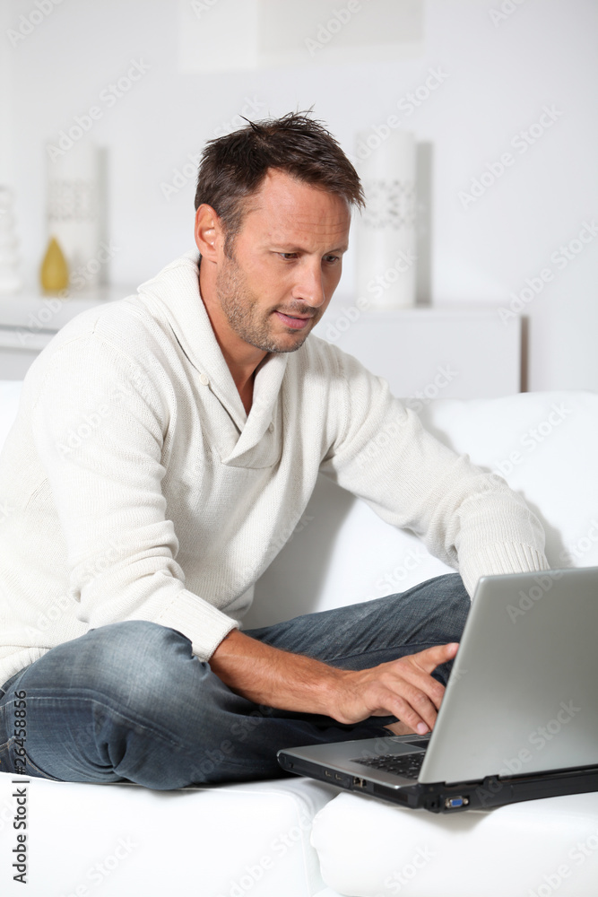 Man with laptop computer sitting in sofa Man with laptop computer sitting in sofa