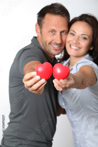 Couple on white background holding red hearts