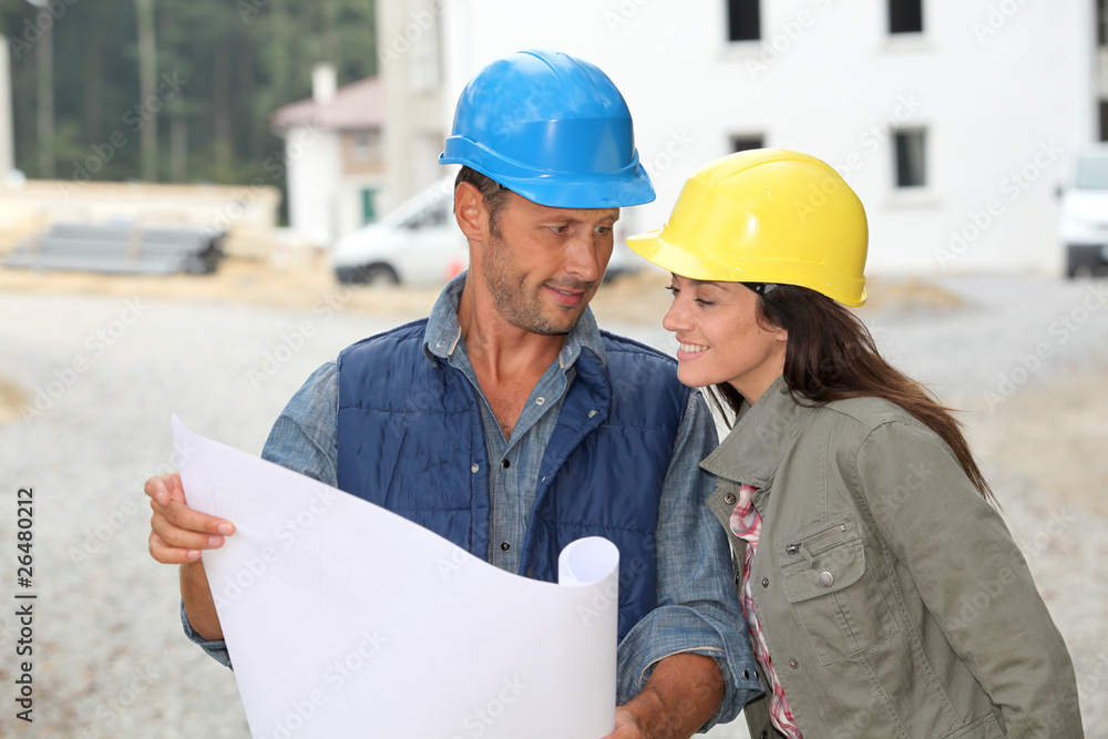 Team of architects checking plans on site Team of architects checking plans on site