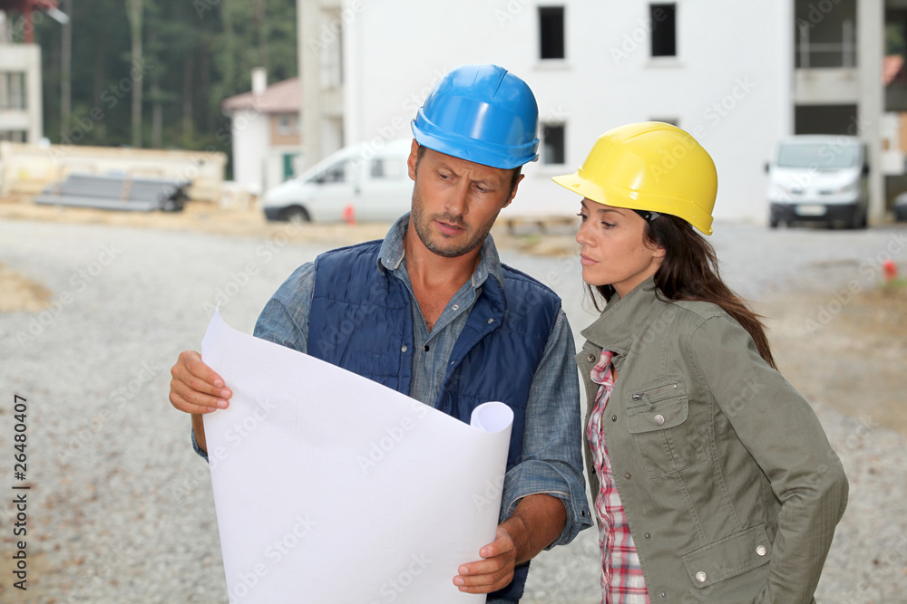 Team of architects checking plans on site Team of architects checking plans on site