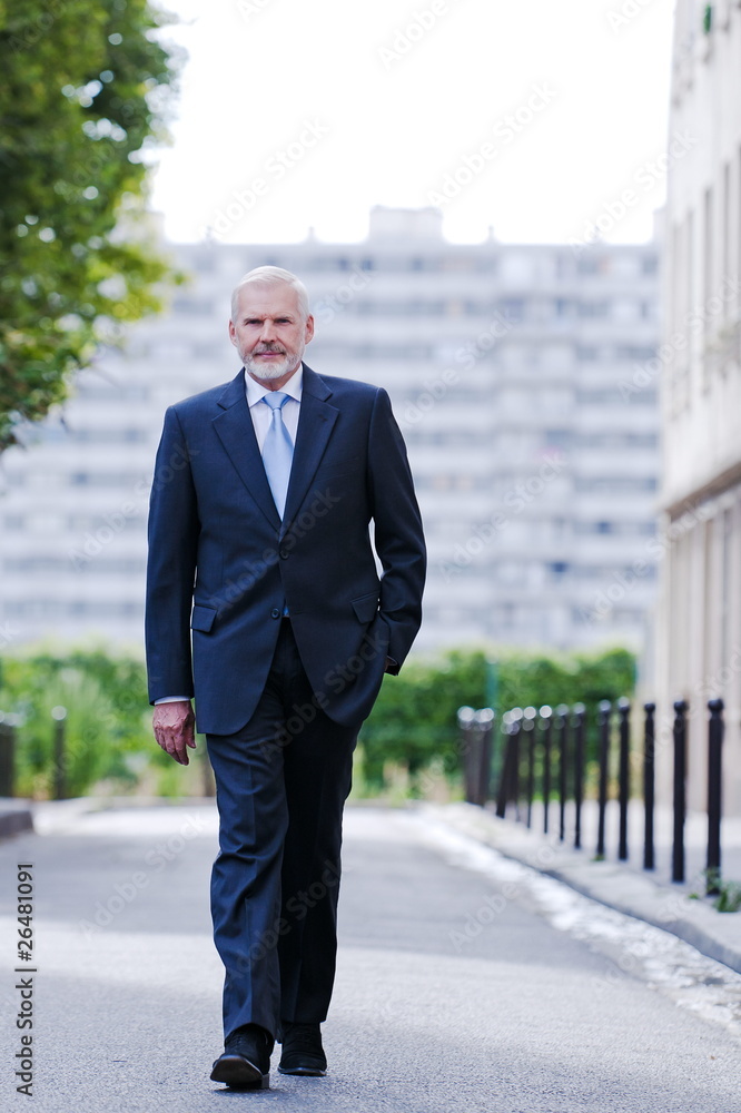 Senior businessman confident walking on the street Senior businessman confident walking on the street
